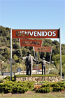 Guadalix de la Sierra. Rotonda de entrada a la villa con los personajes del empresario flamenco Manolo (interpretado por el actor Manolo Morn), en primer plano, y el alcalde don Pablo (interpretado por el actor Pepe Isbert), al fondo de espaldas, de la pelcula Bienvenido, Mr. Marshall